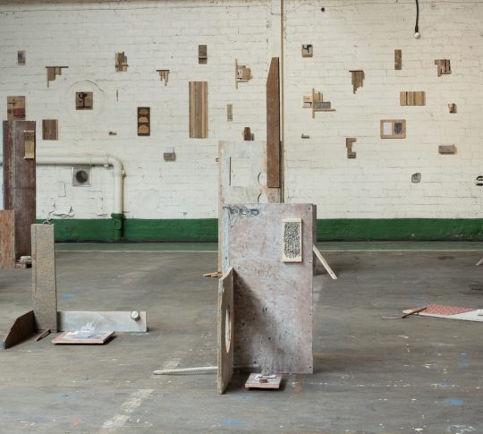 Image of David Lemm's work in wood and paper installed on the floor of an industrial building.